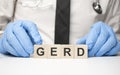 cubes with the word gerd on doctor's hand. Care concept