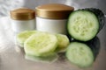 Cucumber cosmetic cream face and hand on wooden background, skin and body care lotion