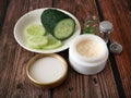 Cucumber cosmetic cream face and hand on wooden background, skin and body care lotion