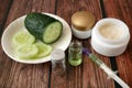 Cucumber cosmetic cream face and hand on wooden background, skin and body care lotion