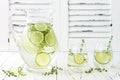 Cucumber infused hydrating water with thyme and lime. Homemade flavored lemonade on rustic old wooden table. Royalty Free Stock Photo