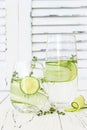 Cucumber infused hydrating water with thyme and lime. Homemade flavored lemonade on rustic old wooden table.