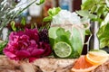 Cucumber lemonade with ice and slices of cucumber and lime in beautiful round glass on the background of fresh flowers Royalty Free Stock Photo