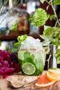 Cucumber lemonade with ice and slices of cucumber and lime in beautiful round glass on the background of fresh flowers Royalty Free Stock Photo