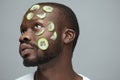 Cucumber Mask. Skin Care For Man`s Beauty Treatment. African Male Model Doing Facecare Routine. Royalty Free Stock Photo