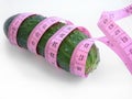 Cucumber with pink tape measure over white background Royalty Free Stock Photo