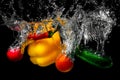 Cucumber, radish, chilli, paprika, tomato in water with spray. Fresh vegetables splashing in water on black background