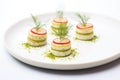 cucumber rounds layered with dill on white plate