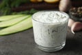 Cucumber sauce in glass bowl with ingredients on table, space for text. Royalty Free Stock Photo