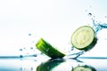 a cucumber slice dropped into water splash with droplets, blurred natural background Royalty Free Stock Photo