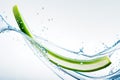 a cucumber slice dropped into water splash with droplets, blurred natural background Royalty Free Stock Photo