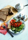 Cucumber and tomato salad, rye bread on white table Royalty Free Stock Photo