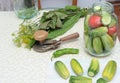 Cucumbers with green hot pepper on the table with glass jar with pickled vegetables cucumber and tomato with herbs and Royalty Free Stock Photo