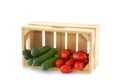 Cucumbers and tomatoes in a wooden crate
