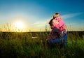 Cuddling children in a field at sunset love Royalty Free Stock Photo