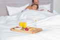 Cuddling couple asleep with breakfast tray on bed Royalty Free Stock Photo