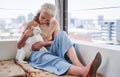 Cuddling with her feline friend. an attractive senior woman cuddling with her cat while relaxing on the balcony at home.