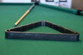 Cue stick and triangle on a green felt pool table with balls racked Royalty Free Stock Photo