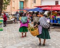 Two poor senior women cross the market in Cuenca. Ecuador