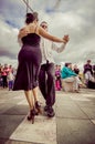 Cuenca, Ecuador - April 22, 2015: Couple performing latin dance styles on city square in front of small crowd