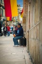 Cuenca, Ecuador - April 22, 2015: Street performer sitting back against wall on top of amplifier singing in city streets Royalty Free Stock Photo