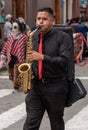 cuenca, Ecuador, Dec 24, 2021 - Man plays saxiphone in the traditional Traveling Child Pase del Nino Christmas Eve