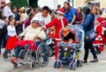 Woman in wheelchair and baby in stroller at parade