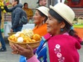 Village woman carries a bowl with bolons, Ecuador