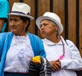 Two elderly women watch passing parade with interest in Cuenca,