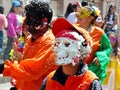 People and dancers are spraying foam on everyone at traditional parade for Carnival in Cuenca