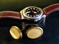 Cuff buttons and male watch on leather top desk