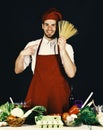 Cuisine and cooking concept. Cook works in kitchen near table with vegetables and tools. Royalty Free Stock Photo