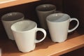 Empty Cups of Coffee Hanging on Wooden Shelves