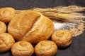 Culinary background with bread,sweet bun,wheat ears,grains on a black background, top view Royalty Free Stock Photo