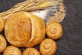 Culinary background with bread,sweet bun,wheat ears,grains on a black background, top view Royalty Free Stock Photo