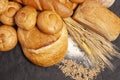 Culinary background with bread,sweet bun,wheat ears,grains on a black background, top view Royalty Free Stock Photo