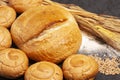 Culinary background with bread,sweet bun,wheat ears,grains on a black background, top view Royalty Free Stock Photo