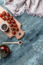 Culinary background with empty wooden cutting board, composition of oil, chili peppers, cherry tomatoes sprig and spices. vertical Royalty Free Stock Photo