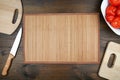 Culinary background: table mat, cutting boards, tomatoes and kitchen knife with copy space Royalty Free Stock Photo