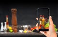 Culinary blog concept with hand shoots the cooking process on the smartphone.