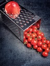 Preparation recipe tomato juice. Large tomato and old grater down to small grape cherry tomatoes on retro vintage rustic gray sto Royalty Free Stock Photo