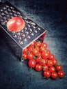 Preparation recipe tomato juice. Large tomato and old grater down to small grape cherry tomatoes on retro vintage rustic gray ston Royalty Free Stock Photo