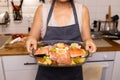 woman cooking salmon fish with vegetables in baking dish in oven at home kitchen Royalty Free Stock Photo