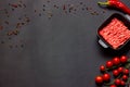 Culinary frame background in dark shades with minced meat, pepper, seasonings, cherry tomatoes, paprika, mustard seeds Royalty Free Stock Photo