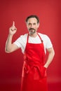 Culinary magic. Cook with beard and mustache wearing apron red background. Man mature cook posing cooking apron. Chief