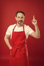 Culinary magic. Cook with beard and mustache wearing apron red background. Man mature cook posing cooking apron. Chief