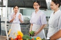 Culinary Students Engaged in Learning with Instructor in Kitchen, Young Chefs Practicing Cooking Techniques with Fresh Ingredients Royalty Free Stock Photo
