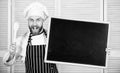 Culinary training. Chief cook teaching master class in cooking school. Man holding wooden spoon and blackboard. Master