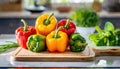 A selection of fresh fruit: bell pepper, sitting on a chopping board against blurred kitchen background copy space