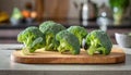 A selection of fresh vegetable: broccoli, sitting on a chopping board against blurred kitchen background copy space Royalty Free Stock Photo